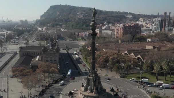 AERIAL: Langzame vlucht over Columbus Monument in Barcelona, Spanje met palmbomen op mooie zonnige dag — Stockvideo
