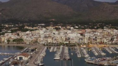 Tropikal Ada 'da limanı olan küçük bir şehir, sabahın erken saatlerinde botları ve okyanusları olan Little Town, Sunrise' da arka planda dağları olan bir şehir. 