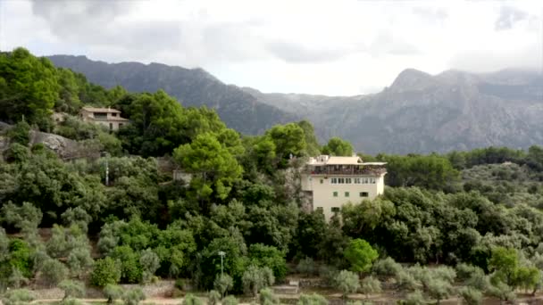 AERIAL: Dom w górach dżungli na tropikalnej wyspie Majorka, Hiszpania na słoneczny dzień wakacje, podróże, słoneczny, fale — Wideo stockowe