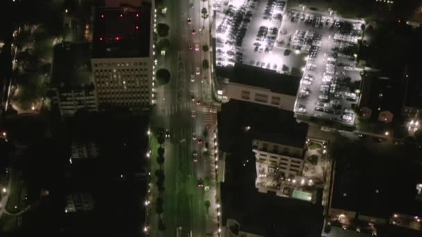 AERIAL: Consulta sobre Wilshire Boulevard Street en Hollywood Los Ángeles por la noche con vista al centro y las calles brillantes y los semáforos de coches urbanos — Vídeo de stock