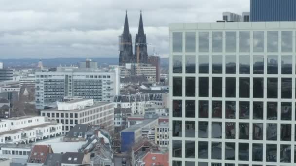 AERIAL: Weitwinkelaufnahme von Köln aus der Luft mit majestätischem Dom und Bürogebäude im Vordergrund an bewölkten Tagen 