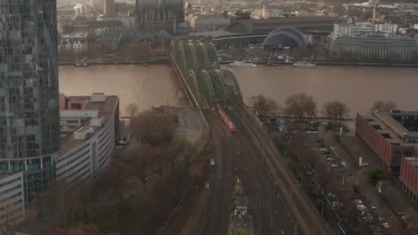 Luftfahrt: Zug überquert Kölner Hohenzollernbrücke an sonnigem Tag mit Dunst am Himmel 
