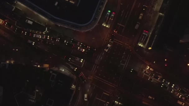 AERIAL: Vacker Overhead Skott av upptagen korsning på natten med Bil trafik och stadsljus — Stockvideo