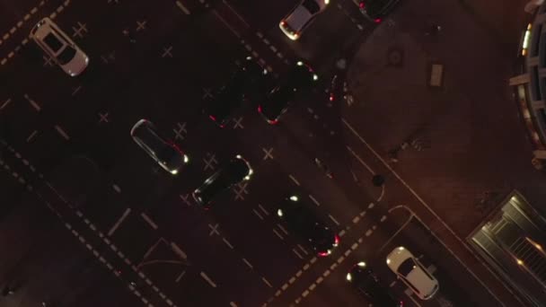 AERIAL: Hermosa toma aérea de intersección ocupada por la noche con el tráfico de coches y luces de la ciudad — Vídeo de stock