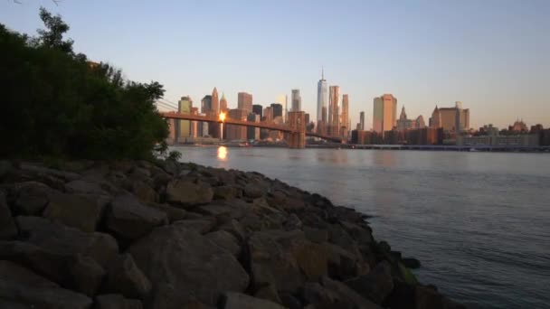 SLOW MOTION: pusat kota Manhattan View dekat dengan air dengan Jembatan Brooklyn di Beautiful Sunrise Sunlight di Summer Water, Morning — Stok Video