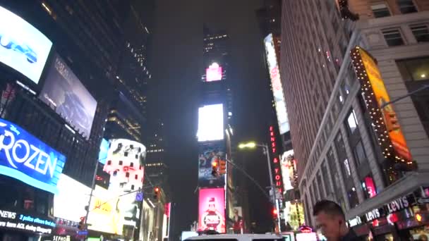 Таймс-сквер освещается ночью трафиком и проходящими мимо людьми — стоковое видео
