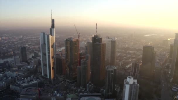 AERIAL: Utsikt över Frankfurt am Main, Tyskland Skyline med solsken mellan skyskrapor i vacker solnedgång solljus i Winter Haze — Stockvideo