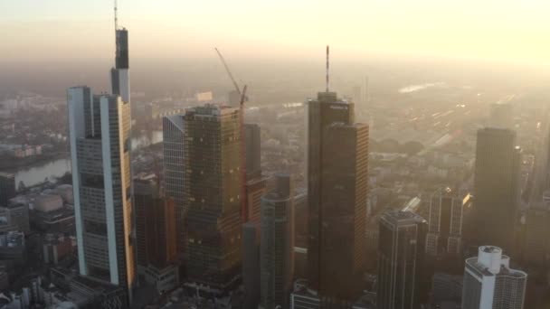 AERIAL: Kilátás Frankfurt am Main, Németország Skyline sunflair között felhőkarcolók gyönyörű naplemente napfény téli ködben — Stock videók