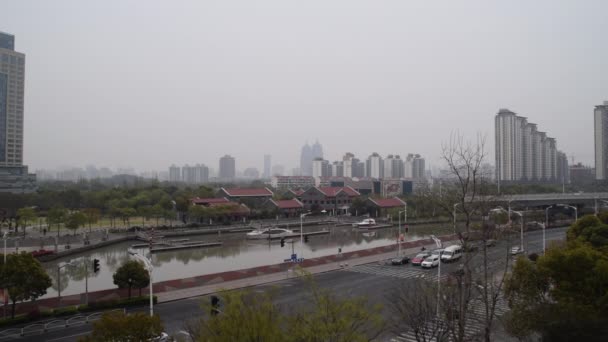 Kruising in Shanghai China op bewolkte dag met autoverkeer langs en rivier in Achtergrond — Stockvideo