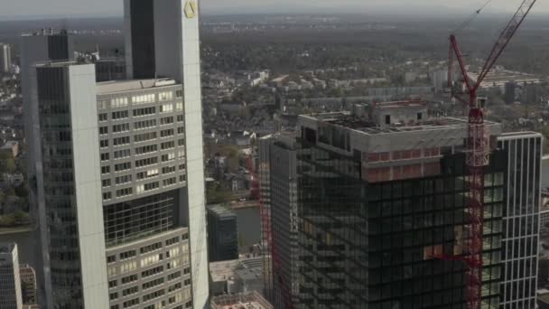 AERIAL: Close Up Zicht op wolkenkrabber bouwplaats in stedelijke omgeving met stadsverkeer en reflecties in toren op zonnige dag in Frankurt am Main Duitsland — Stockvideo