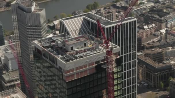 AERIAL: Super zblízka Pohled na staveniště mrakodrapu v městském prostředí s městskou automobilovou dopravou a odrazy ve věži za slunečného dne ve Frankurtu nad Mohanem Německo — Stock video