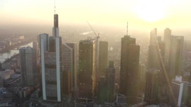 Frankfurt am Main 'in görüntüsü, Almanya gökdelenler arasında güneşli bir gökyüzü ile kışın güzel gün batımı sisinde