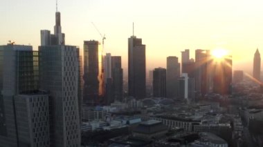 Frankfurt am Main 'in görüntüsü, Almanya gökdelenler arasında güneşli bir gökyüzü ile kışın güzel gün batımı sisinde
