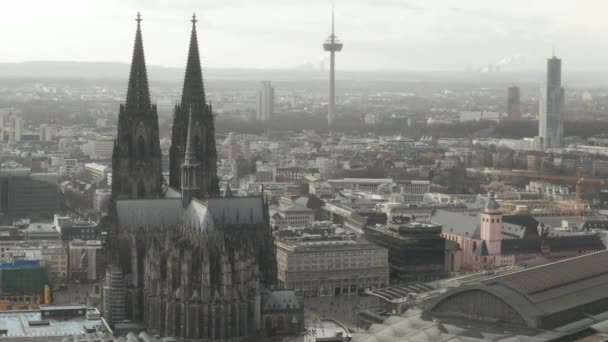 AERIAL: Krążenie wokół pięknej katedry w Kolonii z Dworcem Centralnym w pięknym mglistym świetle słonecznym — Wideo stockowe