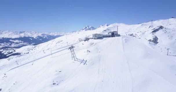 AERIAL: Volo sopra la stazione sciistica nelle Alpi svizzere LAAX pieno di neve bianca nella bella giornata soleggiata — Video Stock