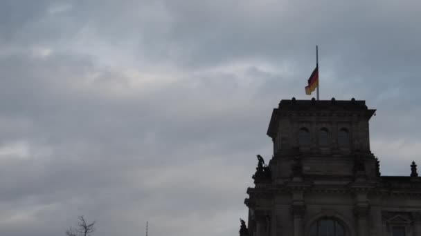 SLOW MOTION: Duitse vlag wapperend in de wind op Bundestag, Reichstag Dak op een bewolkte dag — Stockvideo