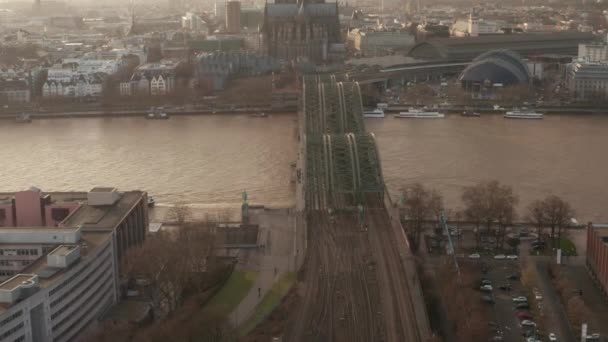 AERIAL: Widok na Kolonię Hohenzollern Bridge i katedry w pięknym mglistym świetle słonecznym — Wideo stockowe