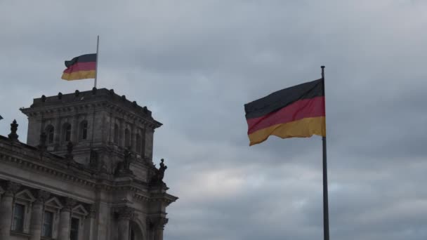 Немецкий флаг размахивает ветром на Бундестаге, крыша Рейхстага в облачный день в Берлине, Германия — стоковое видео