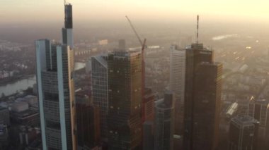 Frankfurt am Main 'in görüntüsü, Almanya gökdelenler arasında güneşli bir gökyüzü ile kışın güzel gün batımı sisinde