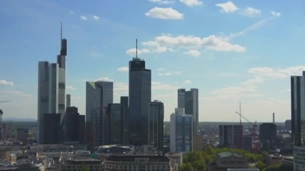 AERIAL: Mit blauem Himmel und strahlender Sonne auf die schöne Skyline von Frankfurt am Main zufliegen — Stockvideo