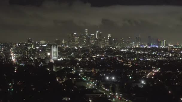 AERIAL: Over Dark Hollywood Los Angeles at Night with Clouds over Downtown and City Lights — стокове відео