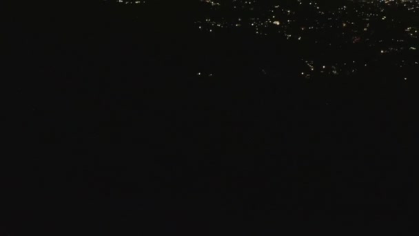 Lento movimiento de inclinación sobre Hollywood Hills en la noche revelando luces de la ciudad de Los Ángeles — Vídeo de stock