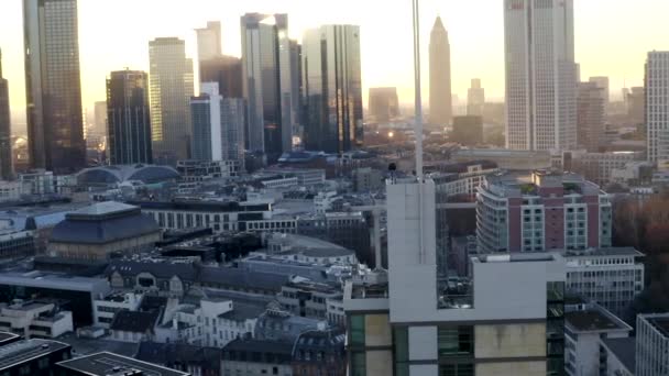AERIAL: Magabiztos fiatalember, Guy álló tetőn Skyline of Frankfurt am Main, Németország gyönyörű napfény télen köd — Stock videók