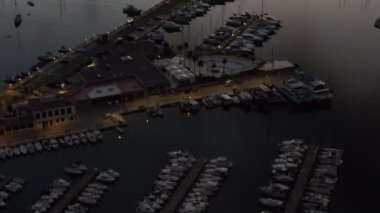 Yelkenli botlar ve okyanusla birlikte Tropikal Ada 'da Sunrise' da Küçük Kasaba 'da arka plandaki dağlarla, seyahatle, günbatımıyla 