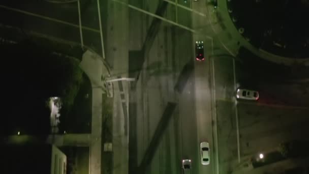 AERIAL: Lookup πάνω από Wilshire Boulevard Street στο Χόλιγουντ Λος Άντζελες τη νύχτα με θέα στους δρόμους και τα φανάρια κυκλοφορίας αυτοκινήτων της πόλης — Αρχείο Βίντεο