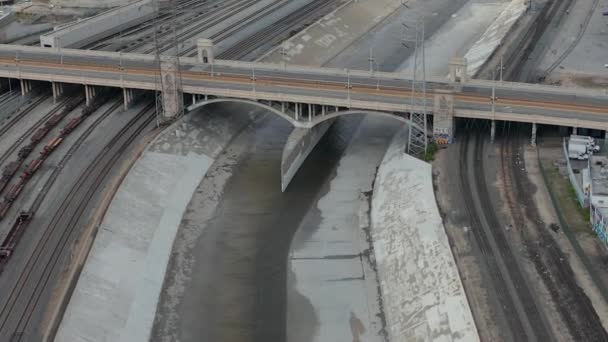 AERIAL: Puente del Río Los Ángeles con el tren de tranvía cruzando el cielo nublado nublado — Vídeo de stock