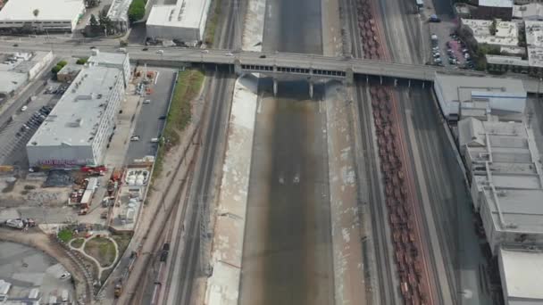 AERIAL: Los Angeles River with Water Tilt up αποκαλύπτοντας Highway και LA Cityscape στον συννεφιασμένο ουρανό — Αρχείο Βίντεο