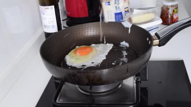 Huevo frito, Huevo Soleado lado arriba que consigue cocinado en la cacerola, huevo que cocina en la luz del día de la cacerola cocina moderna — Vídeo de stock