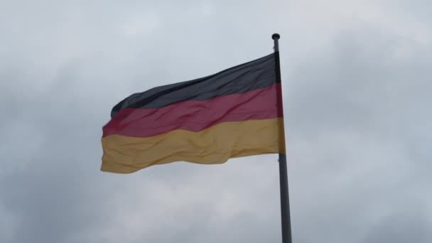 SLOW MOTION: Zbliżenie pięknej flagi niemieckiej machając na wietrze z zachmurzeniem — Wideo stockowe