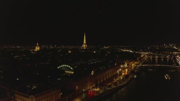 AERIAL: Vista sobre el río Sena por la noche en París, Francia con vista a la Torre Eiffel, Tour Eiffel Luz brillante y hermosas luces de la ciudad — Vídeos de Stock