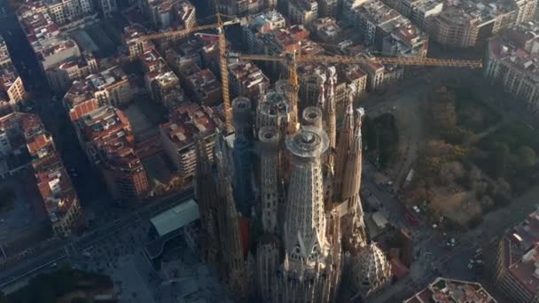 AERIAL: Close up Circling La Sagrada Familia with Cranes in Beautiful City Sunny Haze over Barcelona, Spain — Stock Video