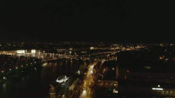 AERIAL: Vista del río Sena en París, Francia por la noche con luces de la ciudad brillante — Vídeo de stock