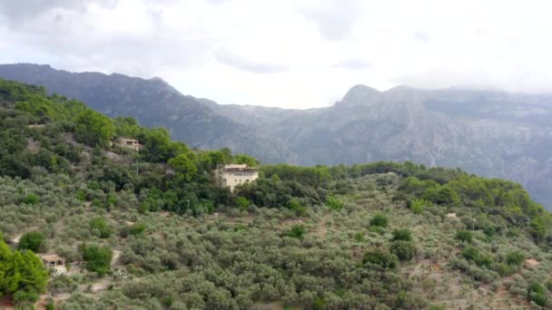AERIAL: W kierunku domu w górach dżungli na tropikalnej wyspie Majorka, Hiszpania na słoneczny dzień wakacje, podróże, słoneczny, fale — Wideo stockowe