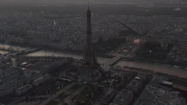 AERIAL: Vuelo en avión no tripulado inverso desde la Torre Eiffel, Tour Eiffel en París, Francia con vista al río Sena con hermosa luz del atardecer — Vídeos de Stock