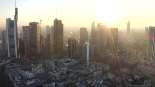 AERIAL: Uitzicht op Frankfurt am Main, Duitsland Skyline met zonneschijn tussen wolkenkrabbers in prachtig zonsondergang zonlicht in Winter Haze — Stockvideo
