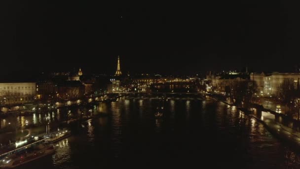 AERIAL: Uitzicht over de Seine 's nachts in Parijs, Frankrijk met uitzicht op de Eiffeltoren, Tour Eiffel en prachtige stadsverlichting — Stockvideo