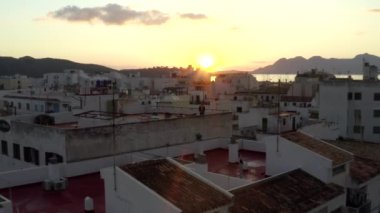 Little Town House 'un çatısında dikilen adam Tropik Ada Limanı ile Sunrise' da botları ve okyanusu olan arka planda dağları olan seyahat, günbatımı olan bir adam. 