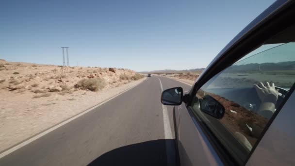スローモーション:暑い晴れた日に乾燥した土地を運転しながらシルバーカーウィンドウからの眺め — ストック動画