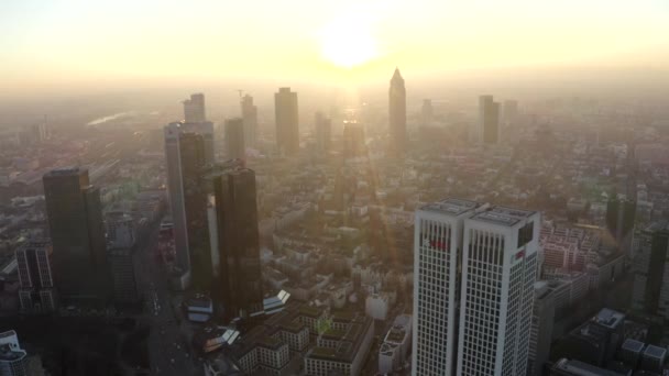 AERIAL: Uitzicht op Frankfurt am Main, Duitsland Skyline met zonneschijn tussen wolkenkrabbers in prachtig zonsondergang zonlicht in Winter Haze — Stockvideo