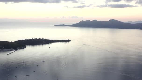 AERIAL: Ozean mit Segelbooten und Tropeninsel mit Bergen im Hintergrund bei SunriseVacation, Reisen, Sonnenuntergang — Stockvideo