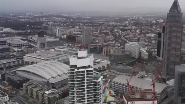 AERIAL: Skyskrapa i konstruktion med Crane på toppen i Frankfurt am Main, Tyskland på Molndagen — Stockvideo
