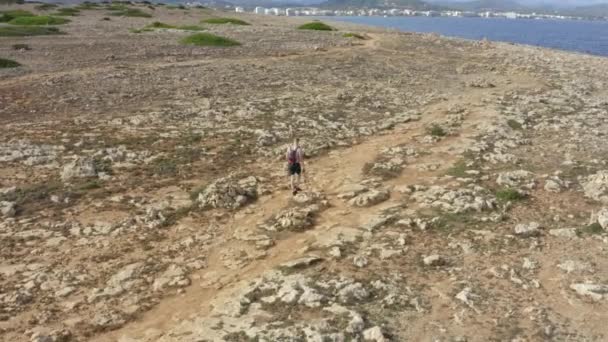 Sırt çantalı adam Rock 'ın üzerinde yürüyor, Sıcak bir günde Tropikal Ada' da Güneşli Hava, Günışığı — Stok video