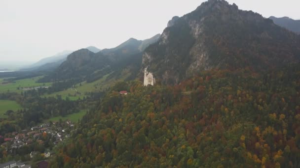 AERIAL: Άποψη του Κάστρου Neuschwanstein σε απόσταση, Βουνά, Καλοκαίρι, ομίχλη — Αρχείο Βίντεο