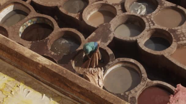 SLOW MOTION: Volwassen man die in water kleurt leer in de traditionele manier in oude stad van Fez, MOROCCO — Stockvideo