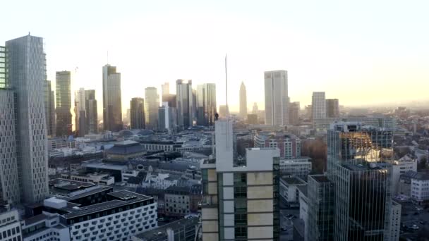 АЭРИАЛ: уверенный молодой человек, парень, стоящий на крыше в Skyline Франкфурта-на-Майне, Германия с "Солнечным светом в зимней дымке" — стоковое видео