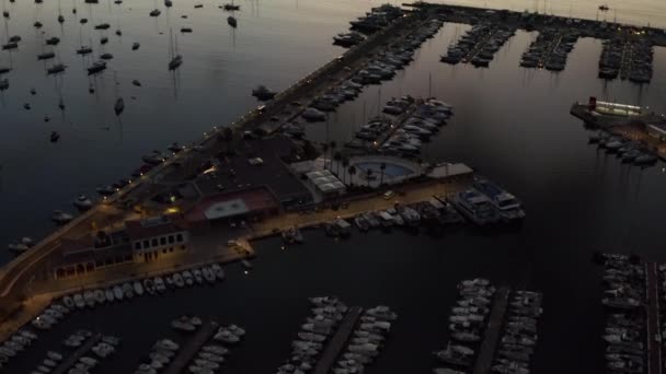 空中:山を背景に日の出と小さな町で帆ボートと海と熱帯島のポート休暇、旅行、日没 — ストック動画